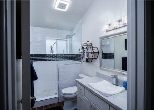Guest bathroom remodel in Phoenix, AZ with wave tile walls, black tile accents, vessel sink, and wall shelving by P. J. Hussey Construction