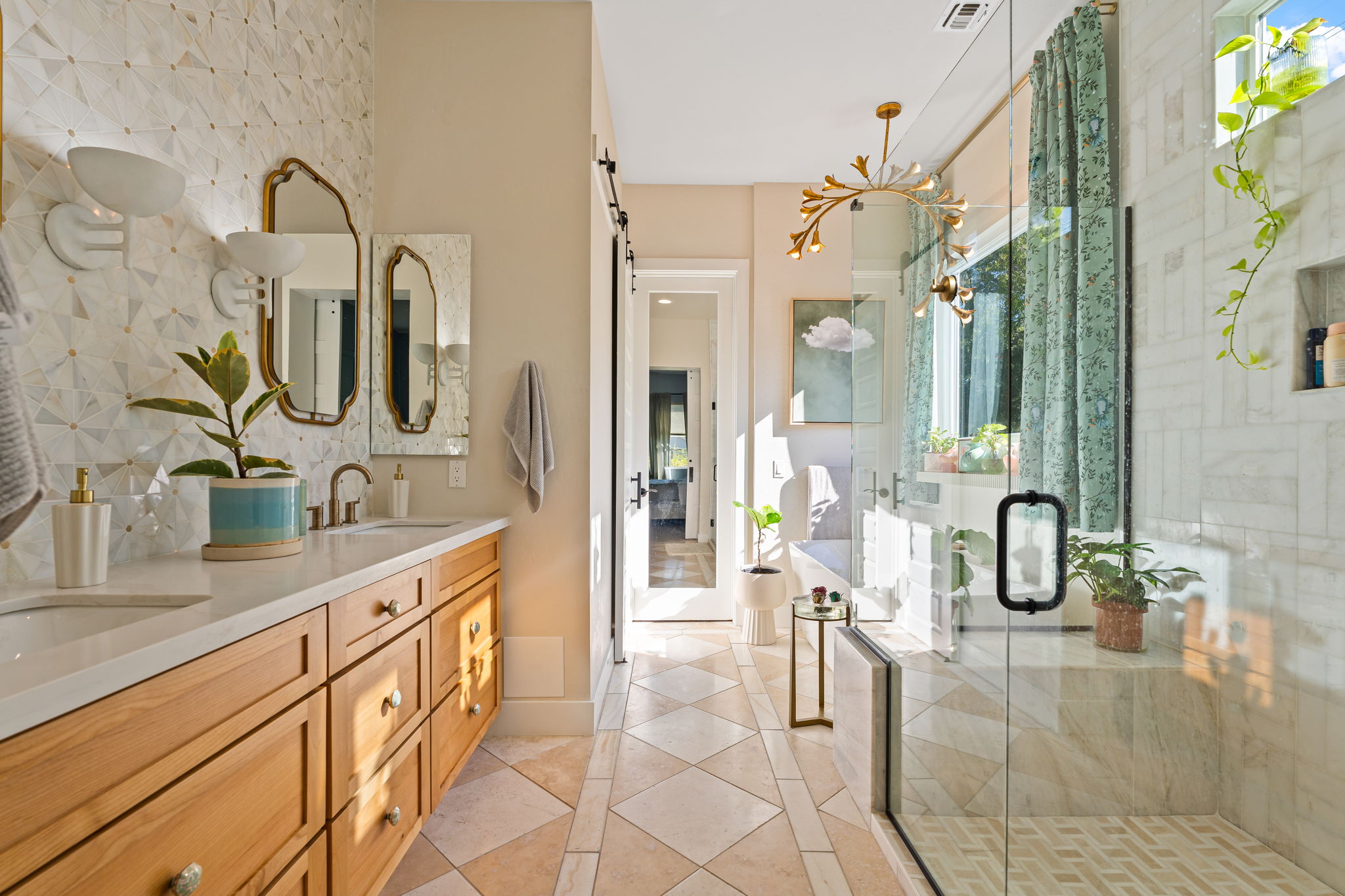 Master bathroom remodel with honey colored vanity, marble counters, gold accent tiles, glass shower and separate tub.