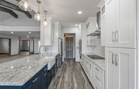 Contemporary kitchen with stainless steel appliances, white cabinetry, and granite countertops.